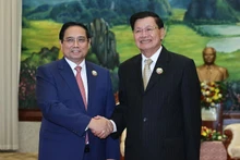 Le Premier ministre Pham Minh Chinh et le secrétaire général du Parti révolutionnaire populaire lao et président du Laos, Thongloun Sisoulith se serrent la main, à Vientiane, le 3 décembre. Photo : NDEL.