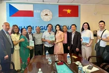 Le traducteur Nguyen Quyet Tien (6e de la gauche) offre au Centre de langue vietnamienne la collection de dictionnaires et de conversations vietnamien-tchèque-anglais qu’il a lui-même rédigée. Photo : VNA.
