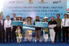 Lors de la cérémonie d'accueil, le comité d'organisation a offert des fleurs et des cadeaux à trois heureux invités du vol VN337 Osaka-Da Nang. Photo : VNA.