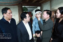 Le vice-Premier ministre Tran Hong Ha (2e de droite) rend visite à l'enfant rescapé du naufrage. Photo : VNA.