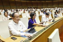Dans le cadre de la 9ᵉ session de la 15ᵉ législature de l’Assemblée nationale, les députés votent l'approbation de la loi modifiant et complétant certains articles de la Loi sur l’organisation du Parquet populaire. Photo : VNA.