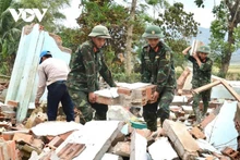 Des soldats du régiment 143 aident les habitants de Hoa Thinh, dans la province de Dak Lak, à dégager les maisons endommagées par les inondations. Photo : VOV.