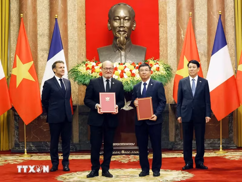 Cérémonie de remise du contrat de crédit pour le projet de renforcement du réseau de transport d’électricité dans le Sud du Vietnam, signé entre l’AFD et EVNNPT, en présence du président français et du président vietnamien. Photo : VNA.