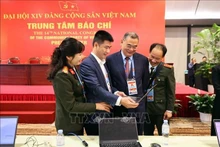 Des reporters travaillent au Centre de presse du XIVe Congrès national du Parti. Photo : VNA.