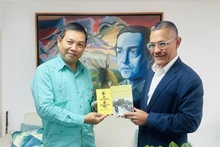 L'ambassadeur vietnamien Vu Trung My (gauche) offre au ministre de la Culture Ernesto Villegas plusieurs œuvres représentatives du Président Ho Chi Minh. Photo : VNA.
