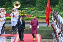 Le président vietnamien Luong Cuong et le roi du Bhoutan Jigme Khesar Namgyel Wangchuck passent en revue la garde d'honneur de l'Armée populaire vietnamienne lors de la cérémonie d'accueil. Photo: NDEL.