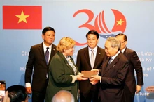 Le président vietnamien Luong Cuong (au milieu) assiste à la cérémonie de restitution des souvenirs de guerre aux vétérans américains et à leurs familles. Photo : NDEL.