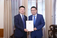 Le directeur du Département consulaire du ministère vietnamien des Affaires étrangères, Doan Hoang Minh, remet l’exequatur à Tang Li, nouveau consul général de Chine à Ho Chi Minh-Ville. Photo : Thanh Long/Baoquocte.