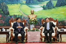 Le secrétaire général et président lao Thongloun Sisoulith et le vice-Premier ministre vietnamien Nguyên Chi Dung (à gauche), lors de leur rencontre à Vientiane, le 9 juillet Photo : VNA.