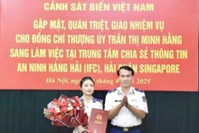 Le général de division Vu Trung Kien, commandant adjoint chargé des affaires juridiques de la Garde-côte du Vietnam, remet la décision à la lieutenante Tran Thi Minh Hang. Photo : La Duy.
