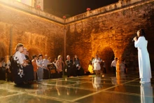 Des visiteurs étrangers vivent une expérience unique en découvrant la Citadelle impériale de Thang Long lors d’une visite nocturne. Photo : Hanoimoi.