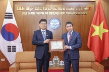Le président de l’Union des organisations d’amitié du Vietnam, Phan Anh Son (à droite), remet l’insigne « Pour la paix et l’amitié entre les peuples » au président du Conseil d’administration de la société par actions DK ENC Vietnam, Jang Chin Hyuk. Photo : Thoidai.