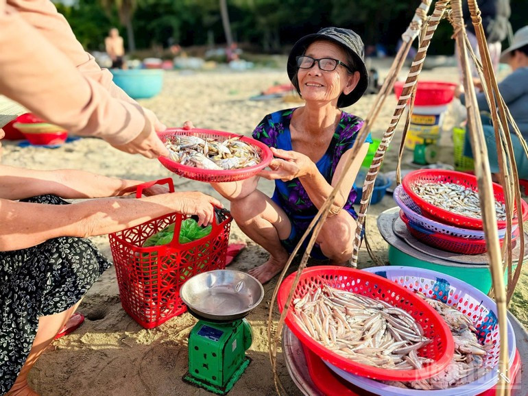Mme Chu Thi Mui achète du poisson dans un bateau-panier et le vend directement sur la plage. a2.jpg