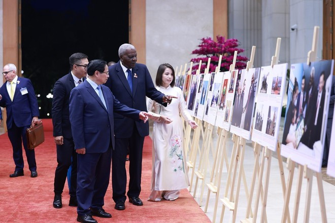 Le Premier ministre Pham Minh Chinh et le président de l'Assemblée nationale de Cuba Esteban Lazo Hernández visitent une exposition de photos sur la coopération entre les deux pays. Photo : VNA. Le Premier ministre Pham Minh Chinh et le président de l'Assemblée nationale de Cuba Esteban Lazo Hernández visitent une exposition de photos sur la coopération entre les deux pays. Photo : VNA.