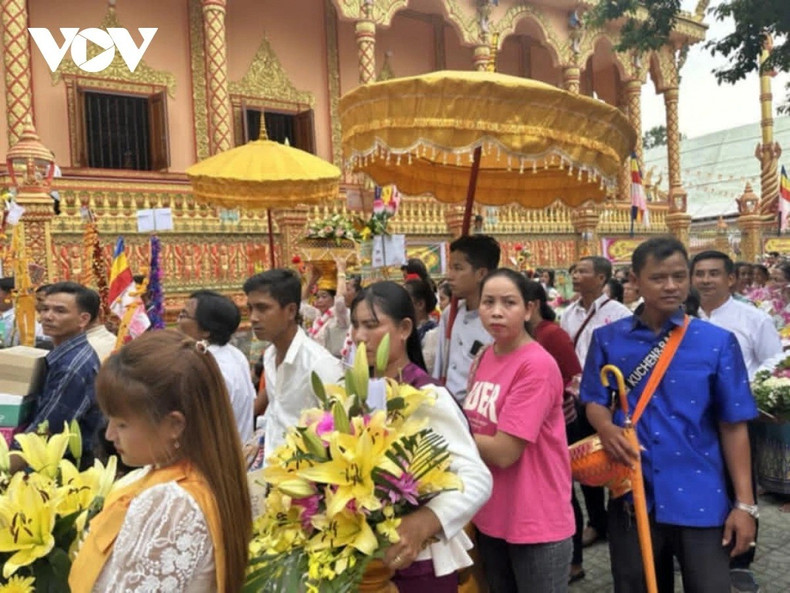 Le maître de cérémonie et les fidèles portent les offrandes et effectuent trois tours autour du sanctuaire principal en hommage au Bouddha. Photo: VOV 2-11zon.jpg