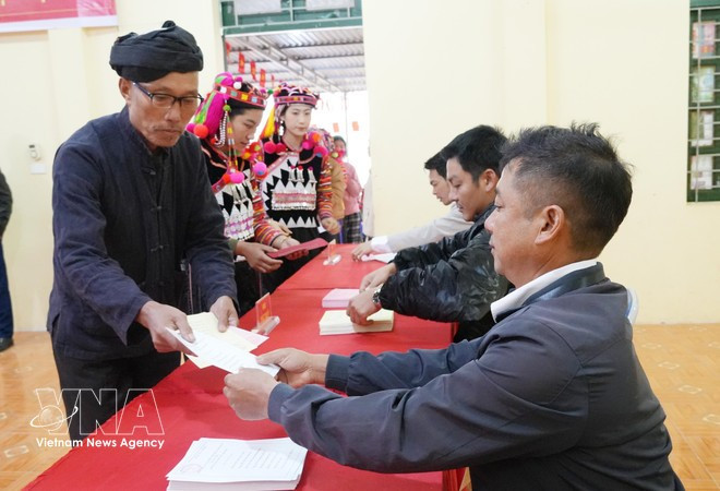 Les premiers électeurs du hameau de Ta Mieu, commune de Sin Thau (province de Dien Bien), reçoivent leurs bulletins de vote. Photo : VNA.