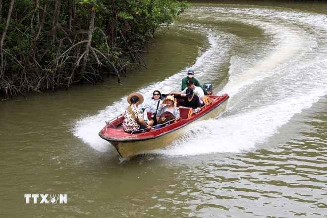 Des visiteurs explorent l'île aux singes de Can Gio en bateau à moteur. (Photo : VNA)