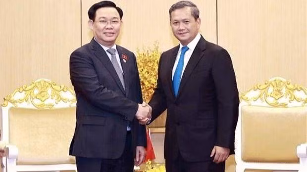 Le président de l’Assemblée nationale du Vietnam Vuong Dinh Huê (à gauche) serre la main du général Hun Manet, commandant en chef adjoint des FARC et commandant de l’Armée de terre des FARC. Photo : VNA.