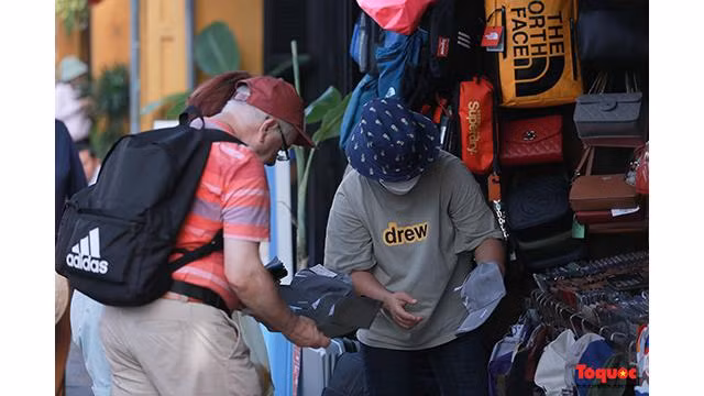 Certains visiteurs se rendent sur les étals pour acheter leurs cadeaux préférés... Photo: Journal Tô Quôc.