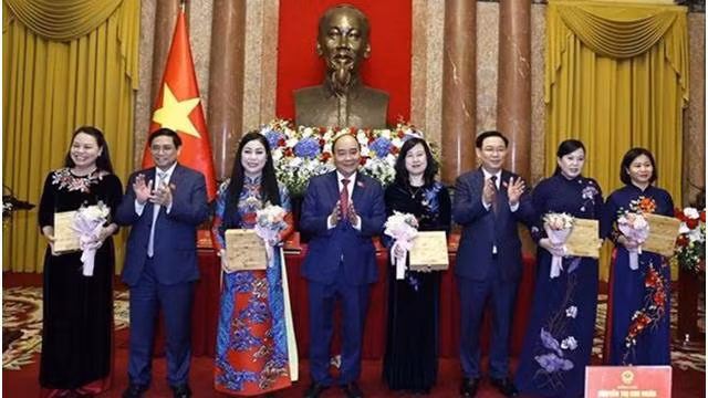 Le Président Nguyen Xuan Phuc (4e, gauche), le Premier ministre Pham Minh Chinh (2e gauche), le Président de l'Assemblée nationale Vuong Dinh Hue (3e, droite) offrent des cadeaux aux déléguées. Photo: VNA