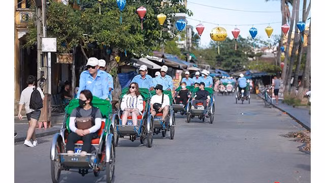 Chaque après-midi, on voit souvent des cyclos transportant des touristes étrangers sur le vieux quartier de Hôi An. Photo : Journal Tôquôc.