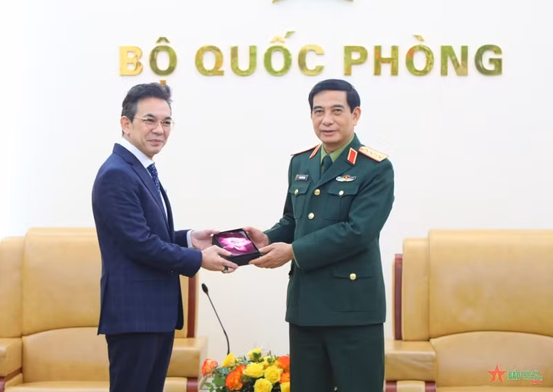 Le général Phan Van Giang (à droite) remet un cadeau de souvenir à l’ambassadeur thaïlandais Nikorndej Balankura. Photo: qdnd.vn