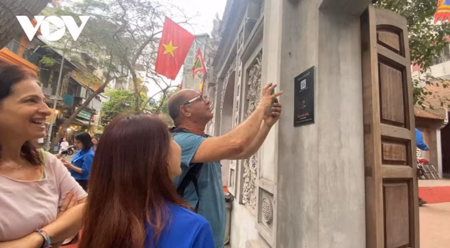 Les visiteurs scannent les codes QR pour accéder aux informations sur les reliques à Hanoï. Photo : VOV.