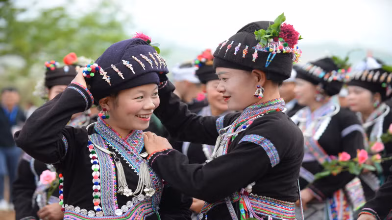 Les femmes s’habillent des foulards et des jupes dans la joie de la fête. Photo : nhandan.vn
