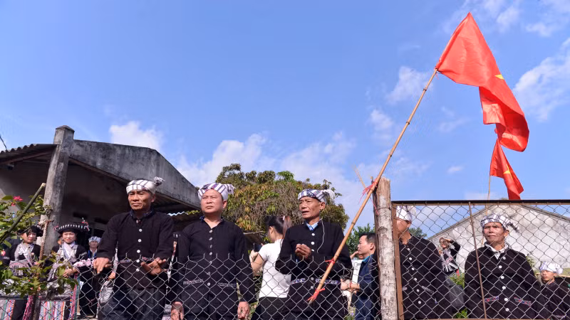 Un groupe chargé de la cérémonie se rend à la maison d'une famille du village pour demander de l'eau, et le célébrant doit demander au propriétaire d’ouvrir la porte et de laisser entrer dans la maison pour chercher de l'eau. Photo : nhandan.vn