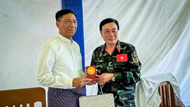 Le général de brigade Pham Van Ty (à droite), vice-directeur du Département des Secours et du Sauvetage relevant de l’État-major général, et chef de la délégation de l'Armée populaire vietnamienne, présente un cadeau au représentant du ministère de la Solidarité sociale, de la Gestion des catastrophes et de la Reconstruction du Myanmar. Photo : nhandan.vn