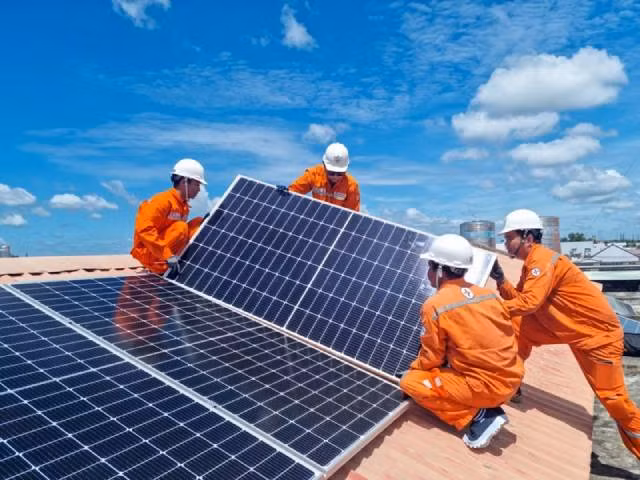 Les ouvriers de la Compagnie générale d'électricité de Hô Chi Minh-Ville installent un système solaire sur le toit. Photo : nhandan.vn