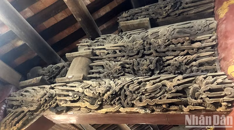 Les motifs sculptés sur la structure en bois de la maison communale. Photo : nhandan.vn