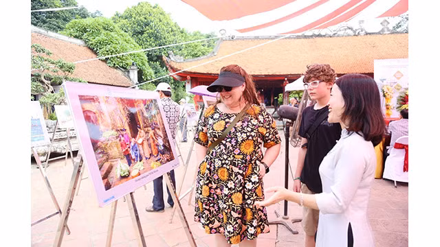 Les touristes visitent l'exposition de photos « Hanoi - 15 ans d'expansion de ses limites administratives » au Temple de la Littérature - Quôc Tu Giam.
