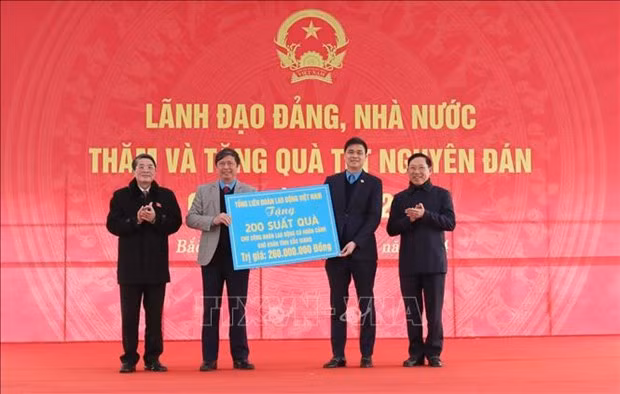  Le vice-président de l’Assemblée nationale Nguyên Duc Hai remet symboliquement 200 cadeaux de Têt aux représentants de la Confédération du travail de la province de Bac Giang. Photo : VNA