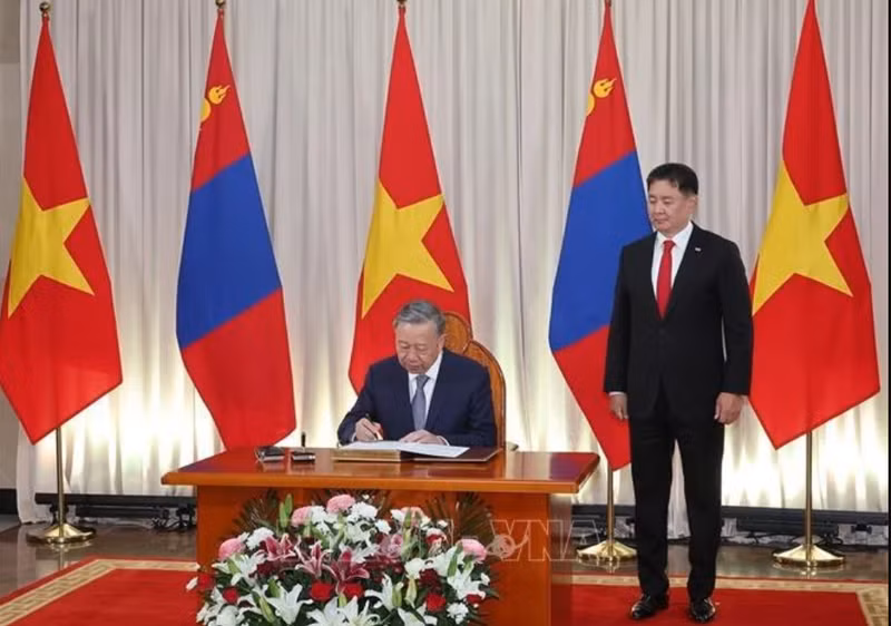 Le secrétaire général du Parti communiste du Vietnam et président de l'Etat, To Lam, signe le livre d'or d'honneur en présence du président mongol Ukhnaagiin Khurelsukh à Oulan-Bator, le 30 septembre. (Photo : VNA)