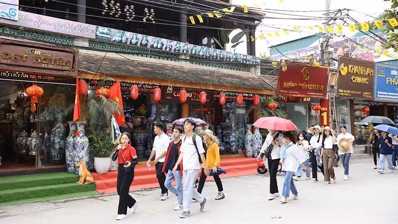 Les touristes visitent le village de poterie de Bat Trang. Photo : nhandan.vn