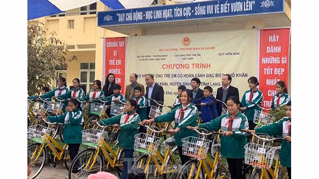 Le groupe de bénévoles a remis 110 bourses avec 1 million de dôngs chacune à 110 enfants démunis du district de Binh Gia ; 50 vélos et des équipements de jeux en plein air pour les enfants démunis du district de Gia Binh. Photo: Tienphong.vn