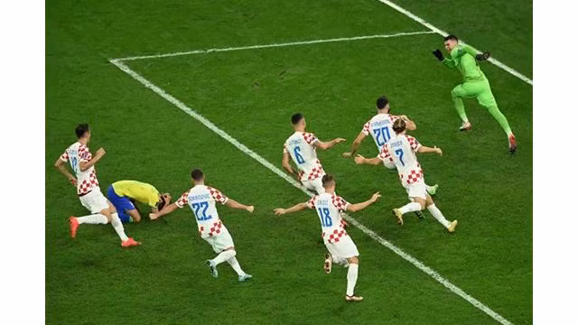Les Croates célèbrent leur qualification pour les demi-finales de la Coupe du monde 2022, vendredi 9 décembre 2022, à Al-Rayyan (Qatar), après le tir au but manqué du Brésilien Marquinhos, agenouillé. INA FASSBENDER / AFP