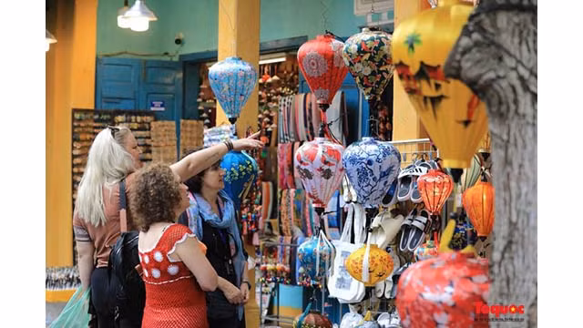 Les touristes internationaux visitent et achètent des lanternes dans l’ancienne ville de Hôi An. Photo : toquoc.vn Les touristes internationaux visitent et achètent des lanternes dans l’ancienne ville de Hôi An. Photo : toquoc.vn