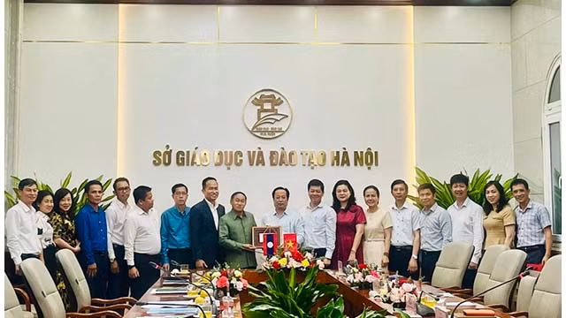 Le dirigeant du Service de l'Éducation et de la Formation de Hanoi présente un cadeau de souvenirs à la délégation du Service de l'Éducation et des Sports de la province de Champassak. Photo : kinhtedothi.vn