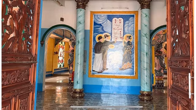 La peinture de « Tam Thanh Ky Thiên Nhân Hoa uoc » représente trois personnages considérés comme des saints de la religion caodaïste, écrivant un traité de paix entre Dieu et l'humanité. Photo : hanoimoi.vn