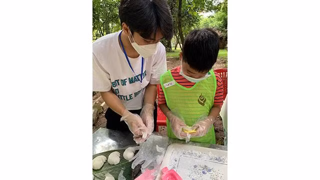 Un petit garçon confectionne un banh deo. Photo : Linh Vi/NDEL. Un petit garçon confectionne un banh deo. Photo : Linh Vi/NDEL.