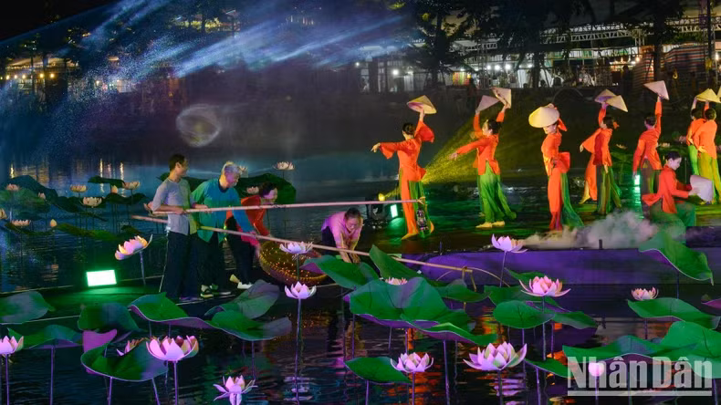 Un programme artistique semi-réaliste « Histoire du Lotus » sur une scène flottante sur l'eau lors de la cérémonie d'ouverture. Photo : nhandan.vn Un programme artistique semi-réaliste « Histoire du Lotus » sur une scène flottante sur l'eau lors de la cérémonie d'ouverture. Photo : nhandan.vn