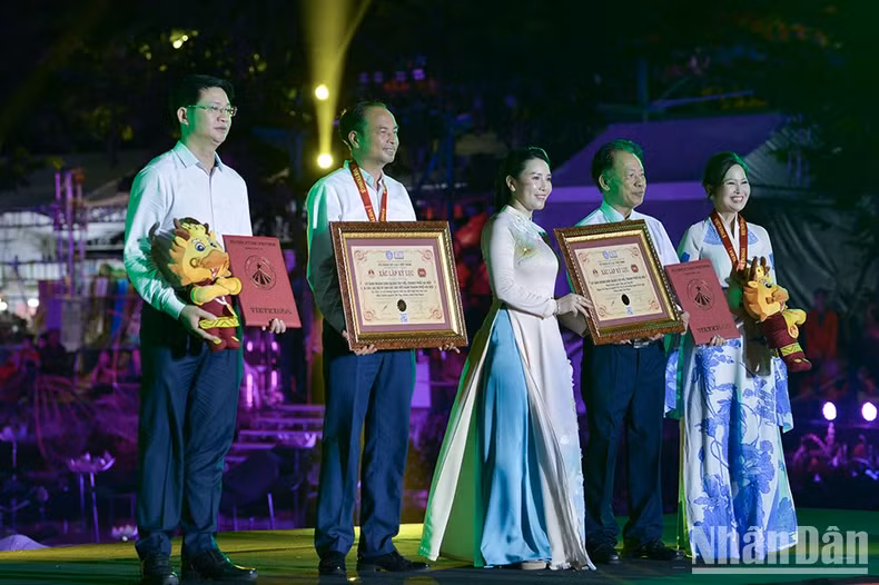 Les organisateurs ont décerné deux records : « Le plus grand nombre de personnes portant l'ao dài (tunique traditionnelle vietnamienne) avec des motifs de lotus au Vietnam » (1 000 personnes) et le record de la course de vélo autour du lac de l’Ouest, avec la plus grande participation de cyclistes (7 000 personnes). Photo : nhandan.vn Les organisateurs ont décerné deux records : « Le plus grand nombre de personnes portant l'ao dài (tunique traditionnelle vietnamienne) avec des motifs de lotus au Vietnam » (1 000 personnes) et le record de la course de vélo autour du lac de l’Ouest, avec la plus grande participation de cyclistes (7 000 personnes). Photo : nhandan.vn