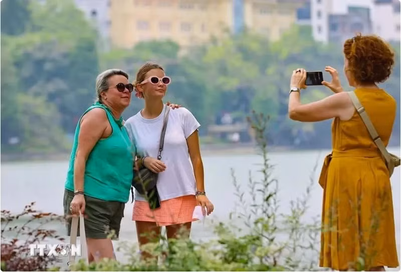Des touristes visitent le lac Hoàn Kiêm, au coeur de Hanoi. Photo : VNA.
