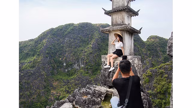 Des touristes prennent des photos dans la zone touristique de la cave de Hang Mua dans la province de Ninh Binh. Photo : VOV. Des touristes prennent des photos dans la zone touristique de la cave de Hang Mua dans la province de Ninh Binh. Photo : VOV.