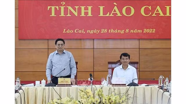 Le Premier ministre Pham Minh Chinh (debout) lors de la séance de travail avec des autorités de Lao Cai. Photo: VNA 