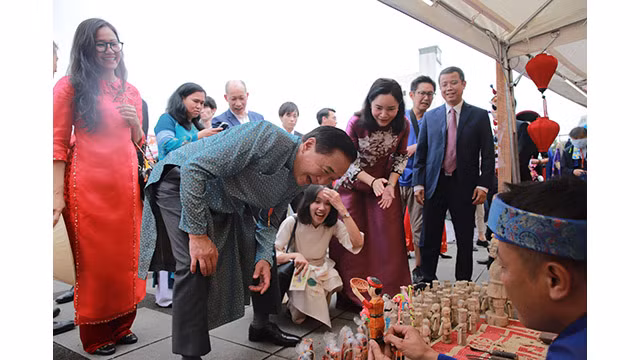 Le gouverneur de la préfecture de Kanagawa s’est arrêté au stand de fabrication des marionnettes et des « tò he » (figurines de pâtes de riz gluant colorées) du ministère de la Culture, des Sports et du Tourisme, et l’a beaucoup admiré. Photo : bvhttdl.gov.vn Le gouverneur de la préfecture de Kanagawa s’est arrêté au stand de fabrication des marionnettes et des « tò he » (figurines de pâtes de riz gluant colorées) du ministère de la Culture, des Sports et du Tourisme, et l’a beaucoup admiré. Photo : bvhttdl.gov.vn