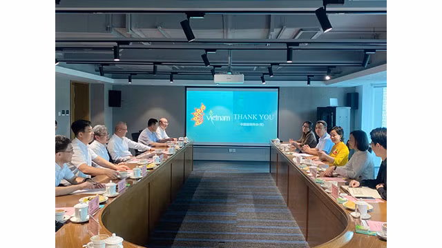 La docteure Trà My, présidente de l’Association provisoire des Entreprises vietnamiennes en Chine (la tunique vietnamienne jaune) lors d'une séance de travail avec le maire de Yantai. Photo : thoidai.com.vn