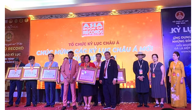 La directrice du Service de la culture, des sports et du tourisme, Huynh Thi Hoài Thu, reçoit le certificat du record d'Asie pour les plats à base de lotus. Photo: dulich.dongthap.gov.vn 